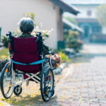 An Alzheimer's patient sits in a wheel chair enjoying some time outside.