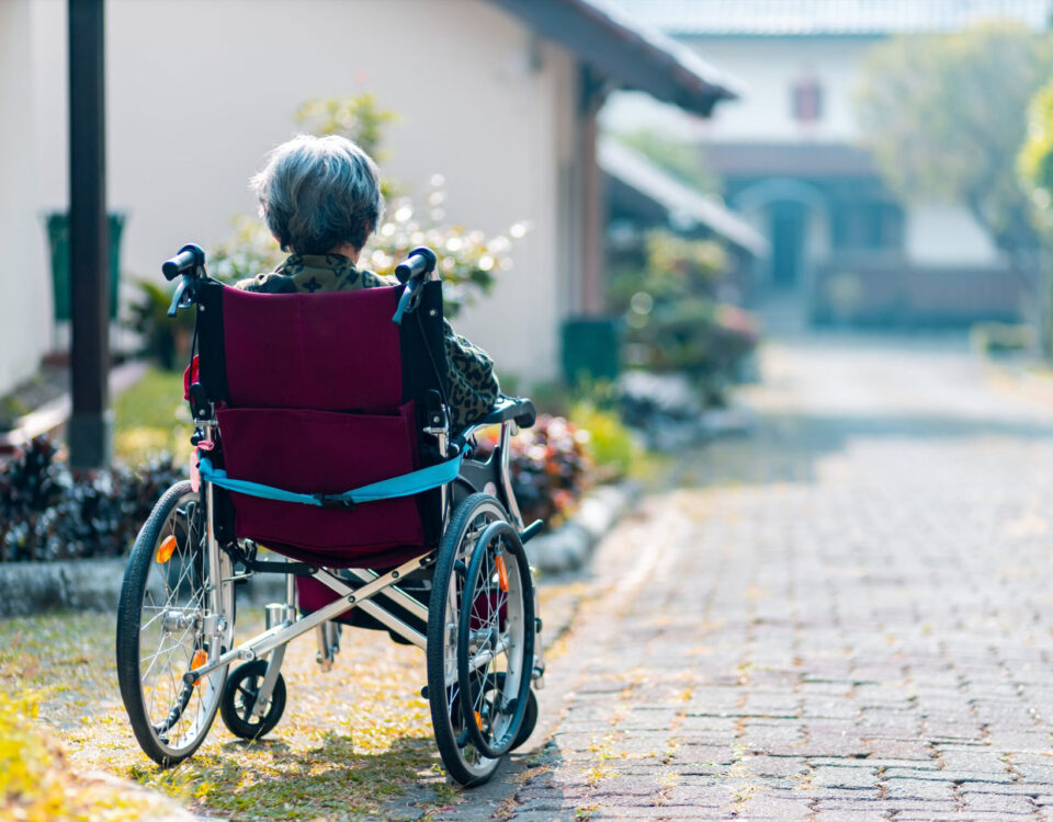 An Alzheimer's patient sits in a wheel chair enjoying some time outside.