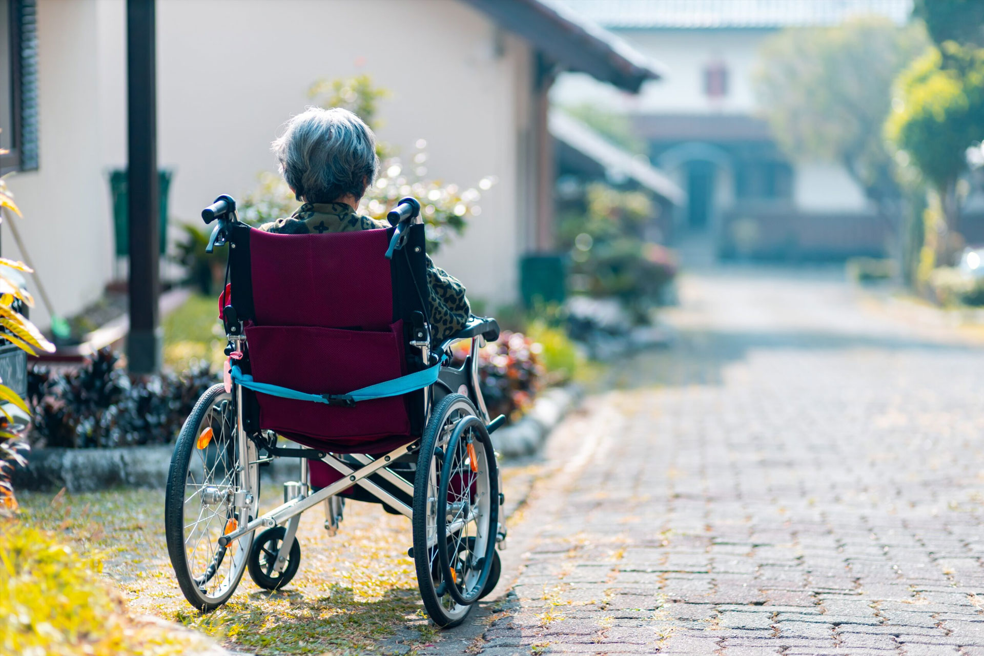 An Alzheimer's patient sits in a wheel chair enjoying some time outside.