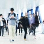 A crowd of people walking down a hallway on a stressful day.