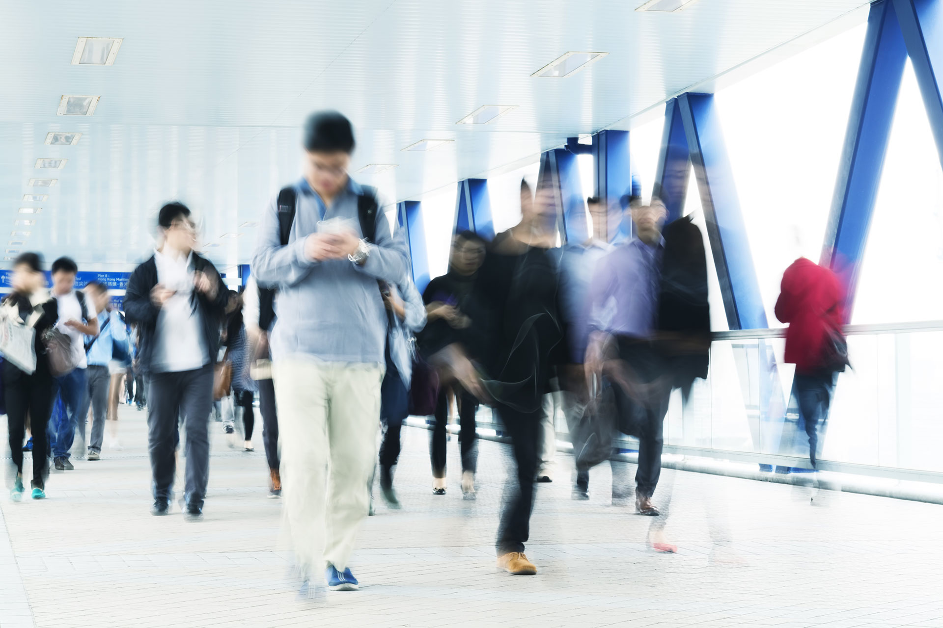 A crowd of people walking down a hallway on a stressful day.