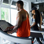 People on treadmills in a gym looking out the window.