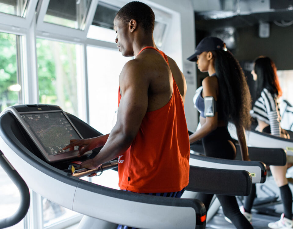 People on treadmills in a gym looking out the window.