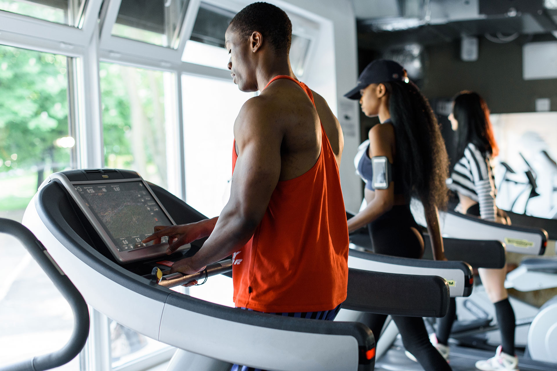 People on treadmills in a gym looking out the window.
