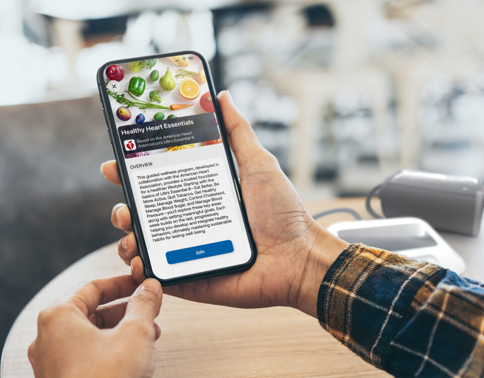 User holding a phone displaying the overview screen of a Guided Wellness Program in the CONNEQT App, with an option to join.