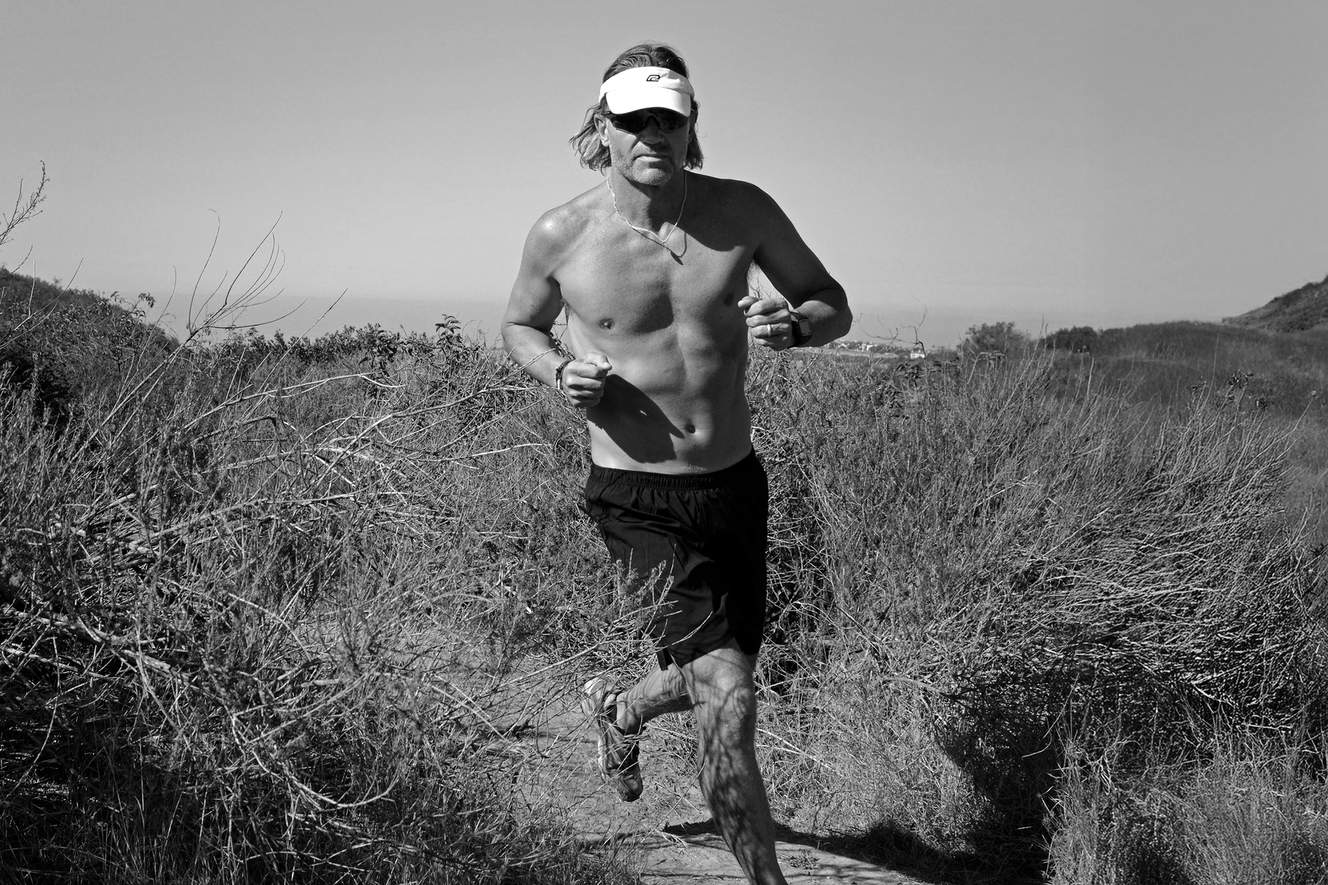 Craig running on a forest trail, reflecting on the cardiovascular risks of long-term endurance training and the importance of heart screening for athletes.
