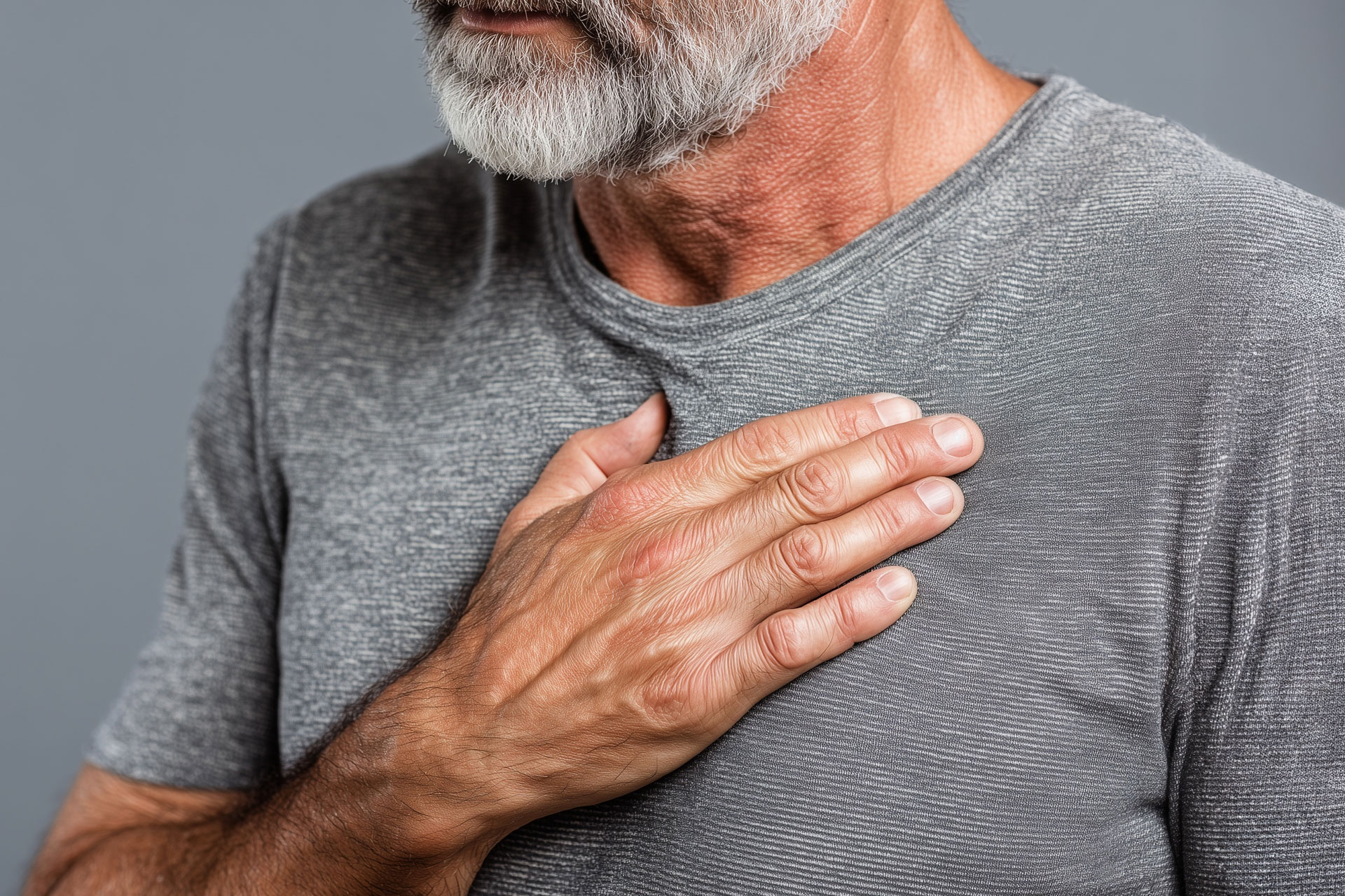 Man standing with his hand over his chest, reflecting subtle changes in cardiovascular health