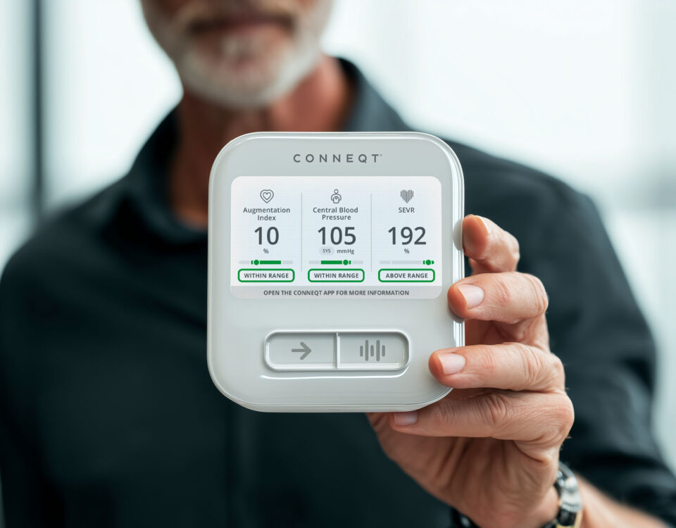 Close-up of the CONNEQT Pulse arterial health monitor showing central blood pressure and arterial health metrics during a reading.