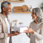 A woman passes a CONNEQT Pulse arterial health monitor to a man.