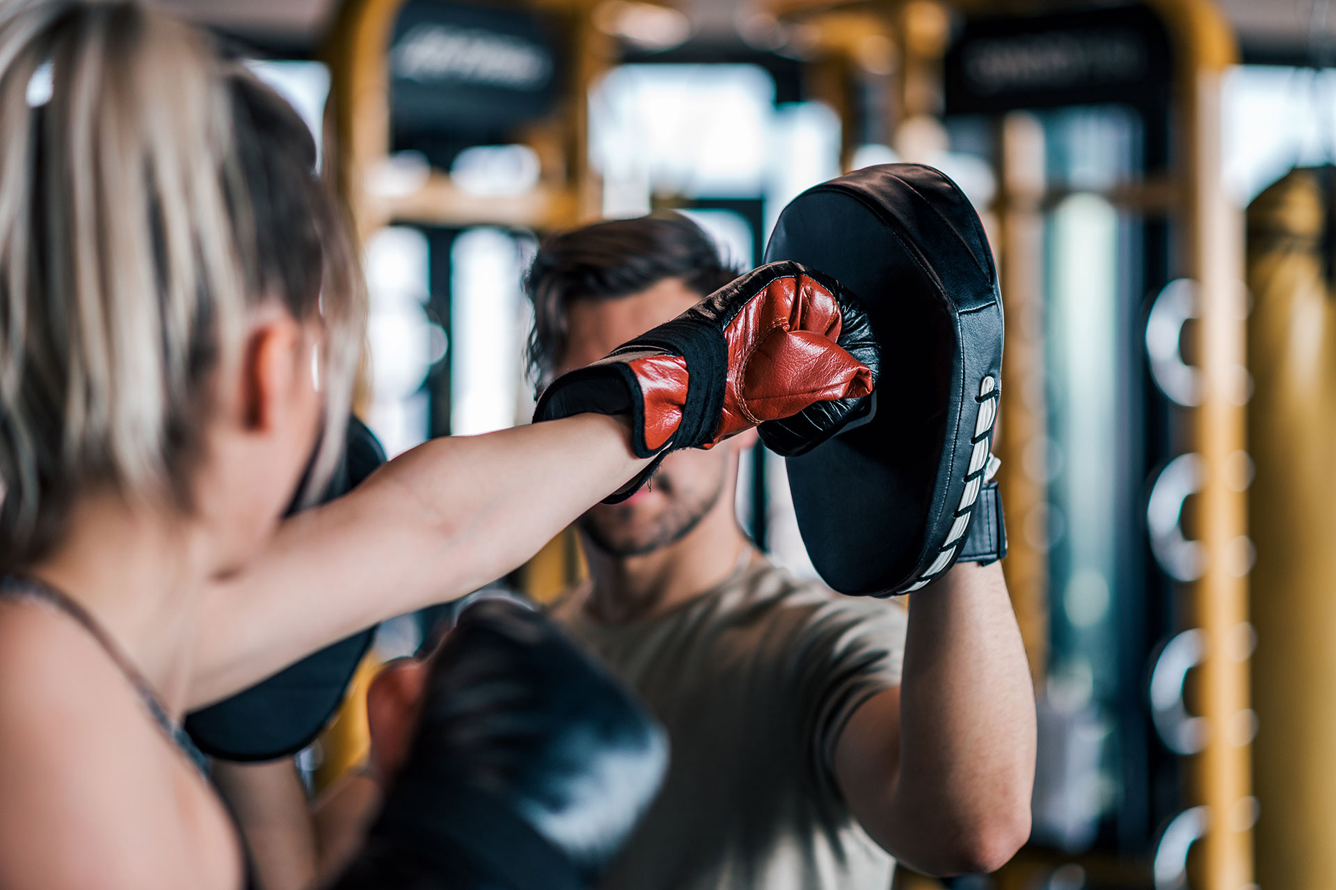 A woman boxing with a trainer to improve her arterial health in her 30s.