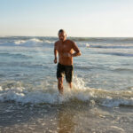 CONNEQT CEO Craig Cooper running out of the water thinking about fit athletes cardiovascular risk.