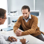 A man meeting with his doctor and considering blood pressure and dementia