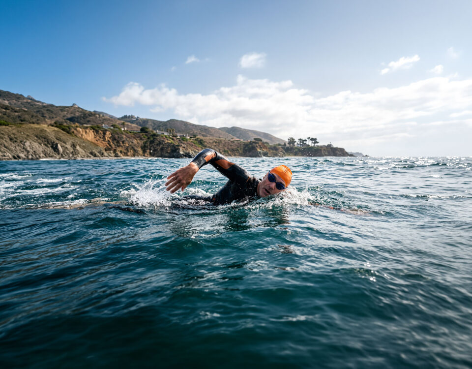 Swimmer in open water pondering how much exercise is too much.