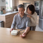 Couple in their kitchen discussing why is my first blood pressure reading higher.